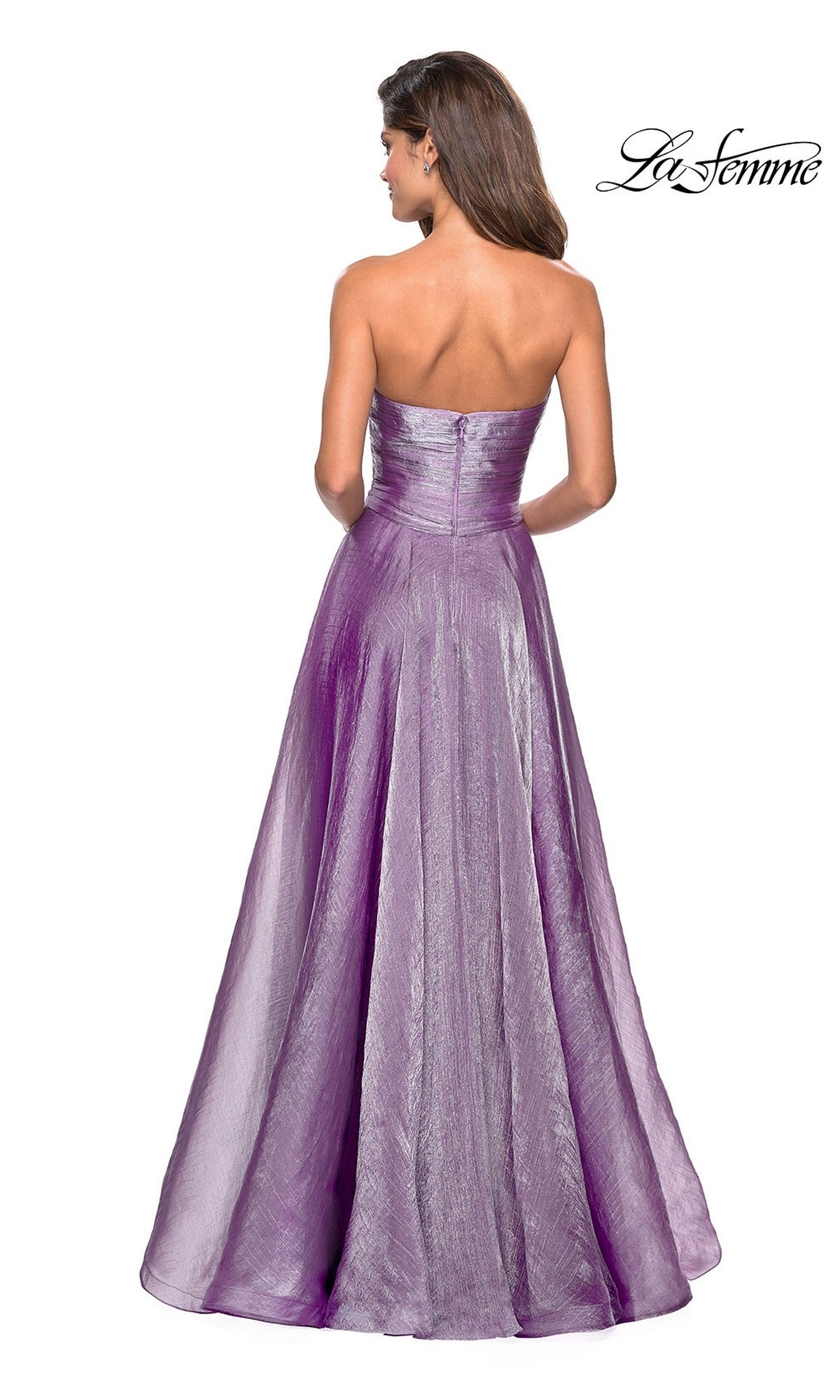 A woman faces away in the shimmery purple La Femme Strapless Long Prom Ball Gown 27515, featuring a strapless sweetheart bodice and floor-length skirt. The brand’s logo appears in the top right corner, highlighting the dress’s elegance.